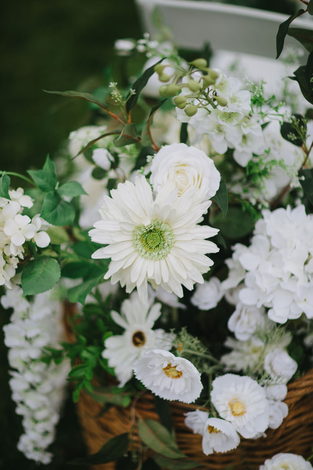 White gerbera daisies and roses with green hypericum berries in a romantic bridal bouquet arrangement