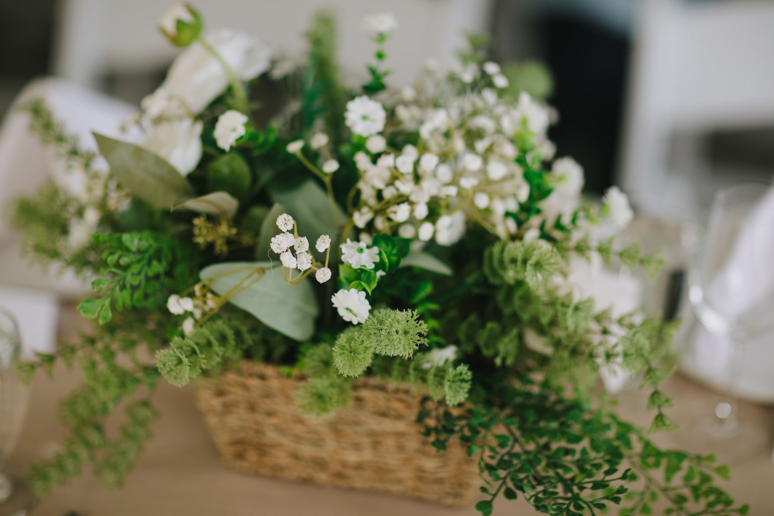 Delicate white baby''s breath and Queen Anne''s lace in a rustic wooden vase with soft natural light