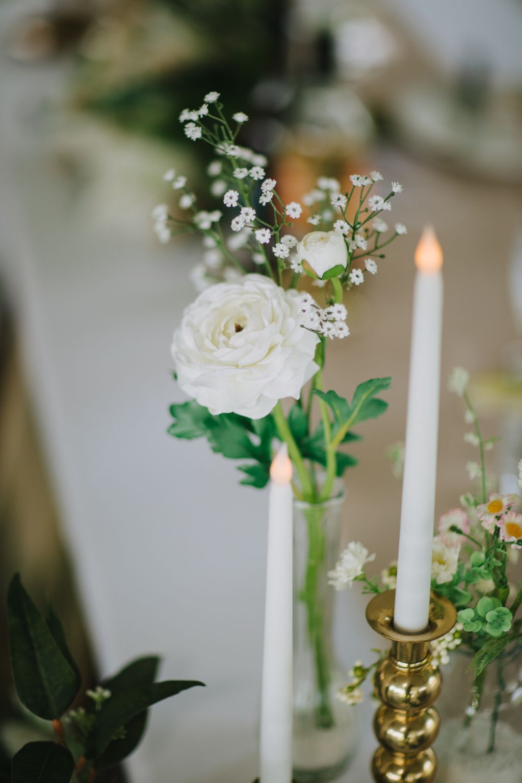 White roses and baby''s breath in a clear glass vase with soft, blurred background