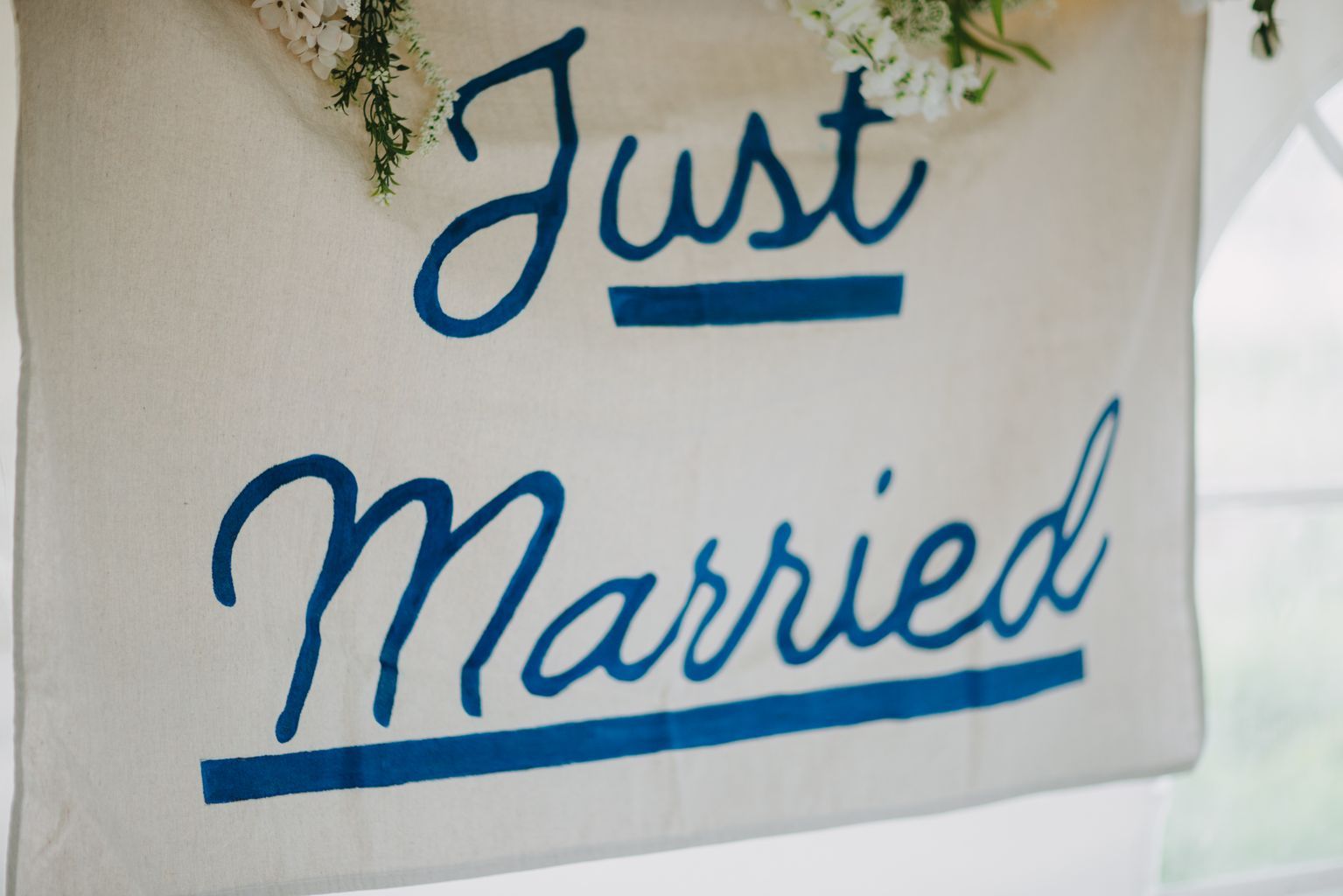 Close-up of handwritten names "Marlee" and "Benjamin" in blue ink on white paper with delicate flowers visible above