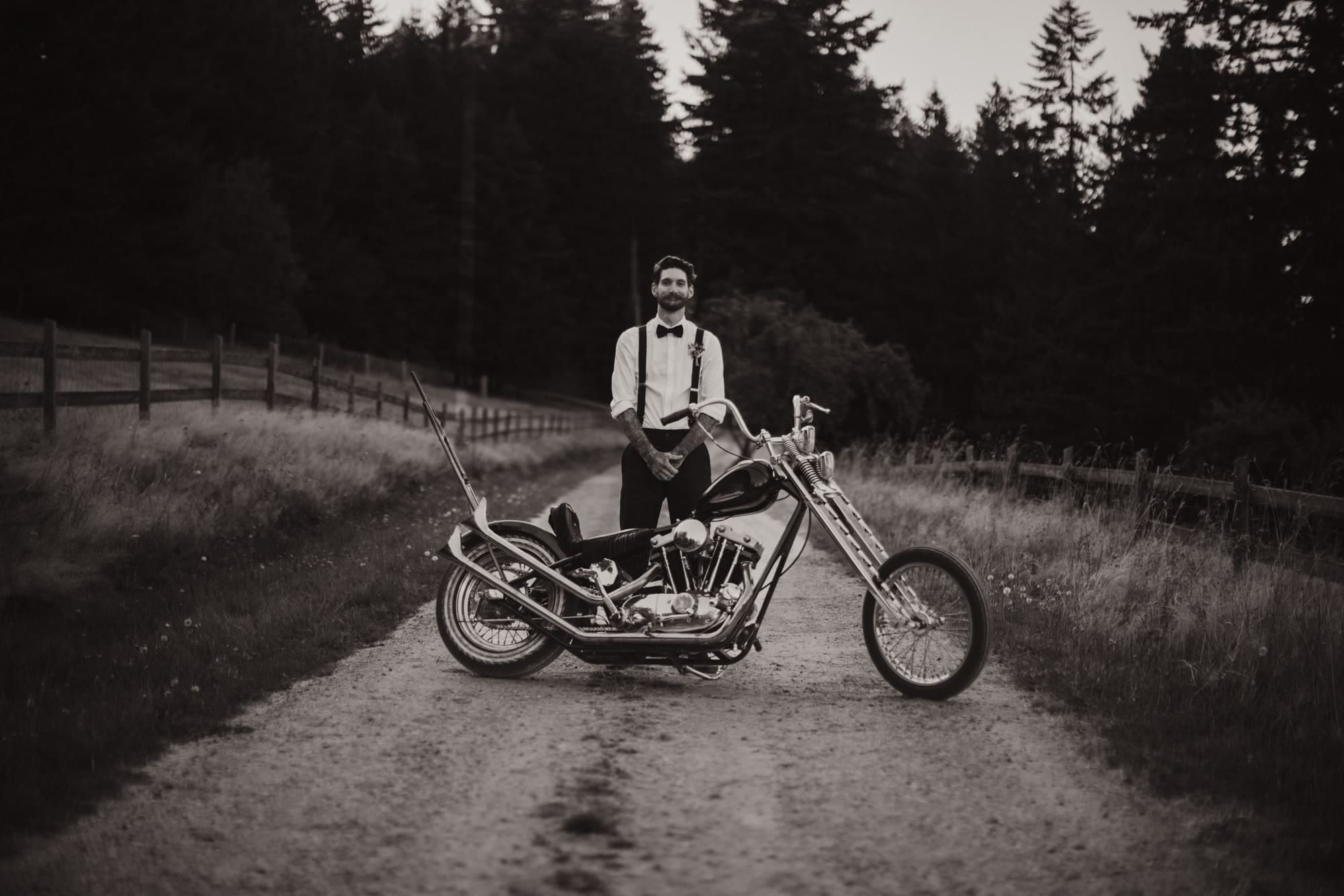 Groom standing beside a vintage motorcycle