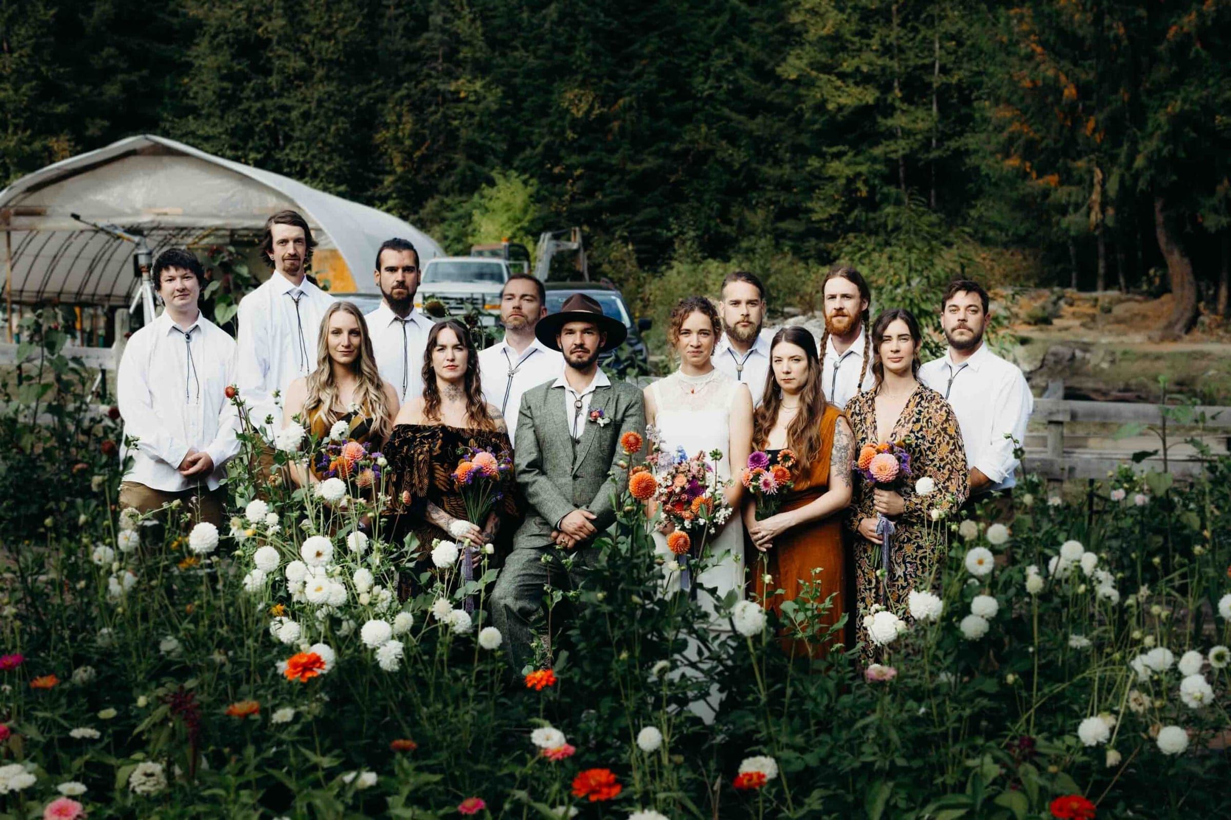 Wedding party gathered together in a white dahlia field