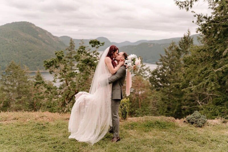 Groom lifting his bride on a bluff at The Summit House