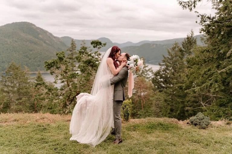 Groom lifting his bride on a bluff at The Summit House