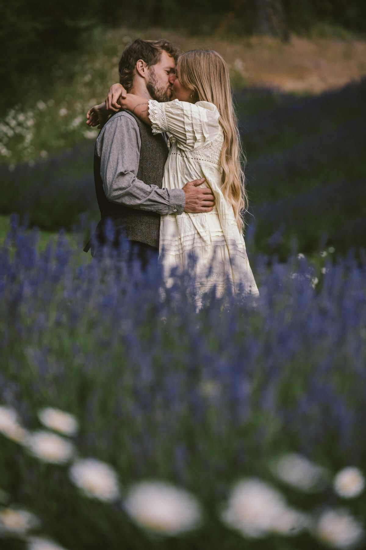 Newlyweds embracing waist-deep in purple lavender blooms