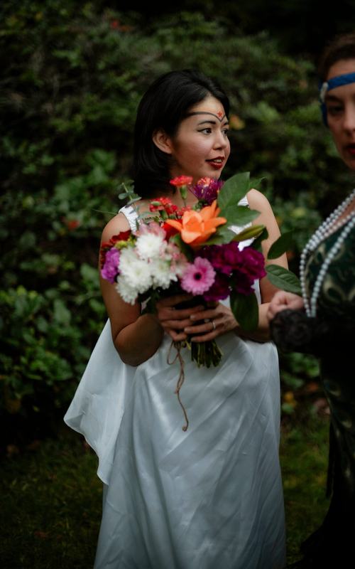Bride holding a vibrant bouquet of orange and magenta blooms