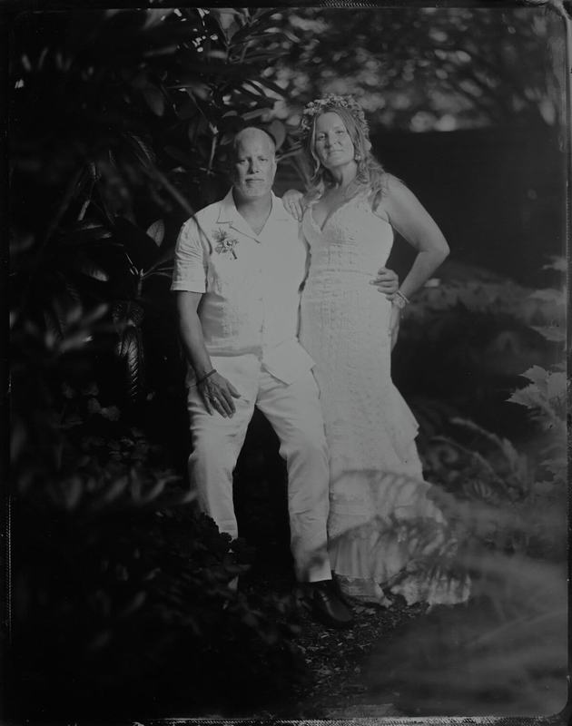 Couple dressed in white surrounded by tropical foliage, tintype