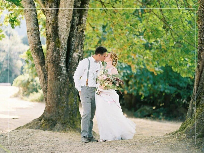 Couple kissing beneath old maples at Mary's Farm & Sanctuary