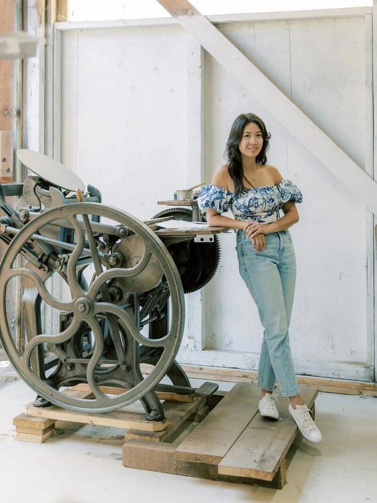 The AYLA View artisan beside a vintage letterpress machine