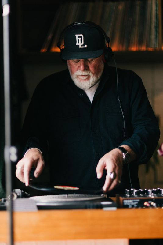 DJ cueing a record between turntable and mixer
