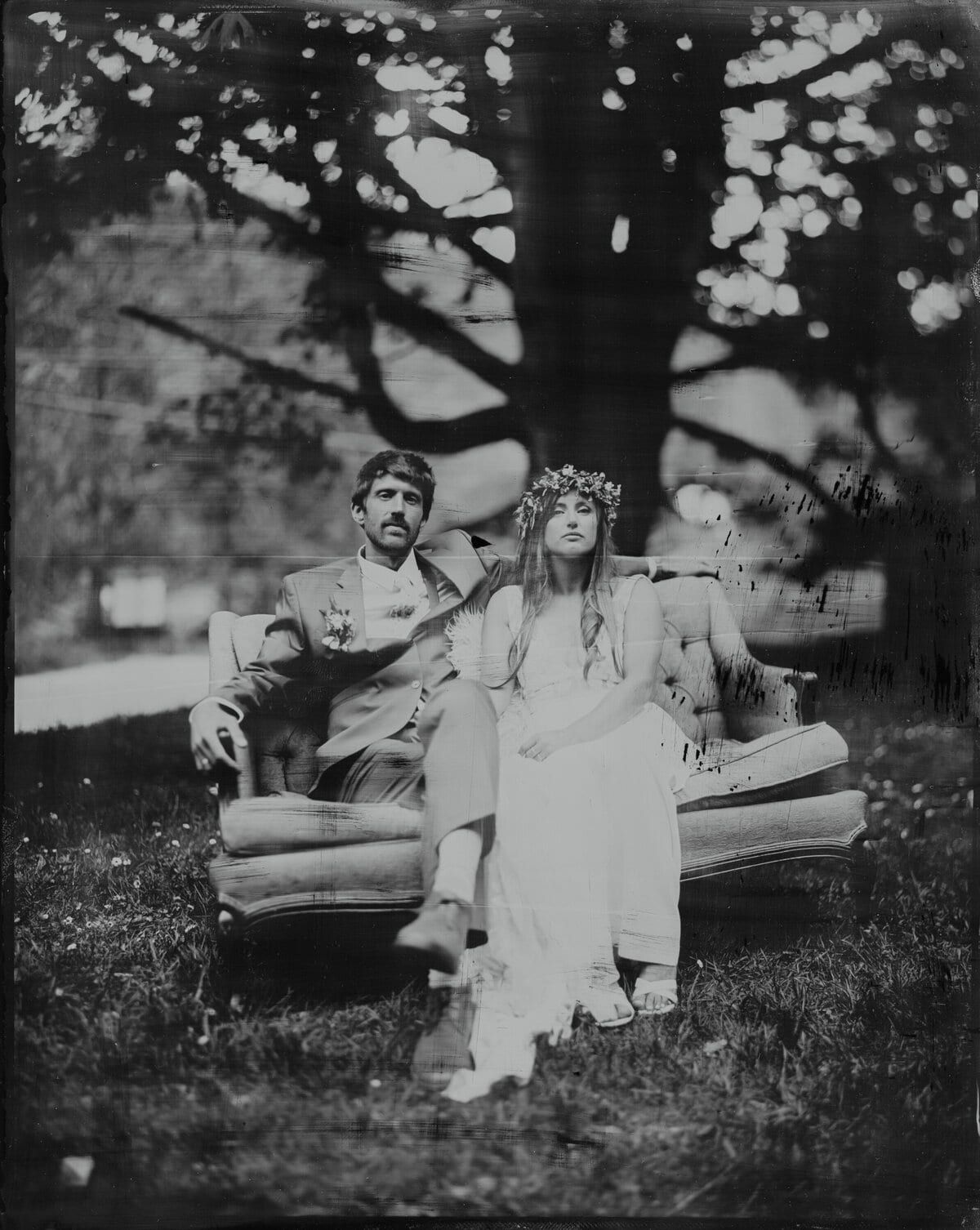 Tintype of a couple seated on a vintage sofa beneath a tree