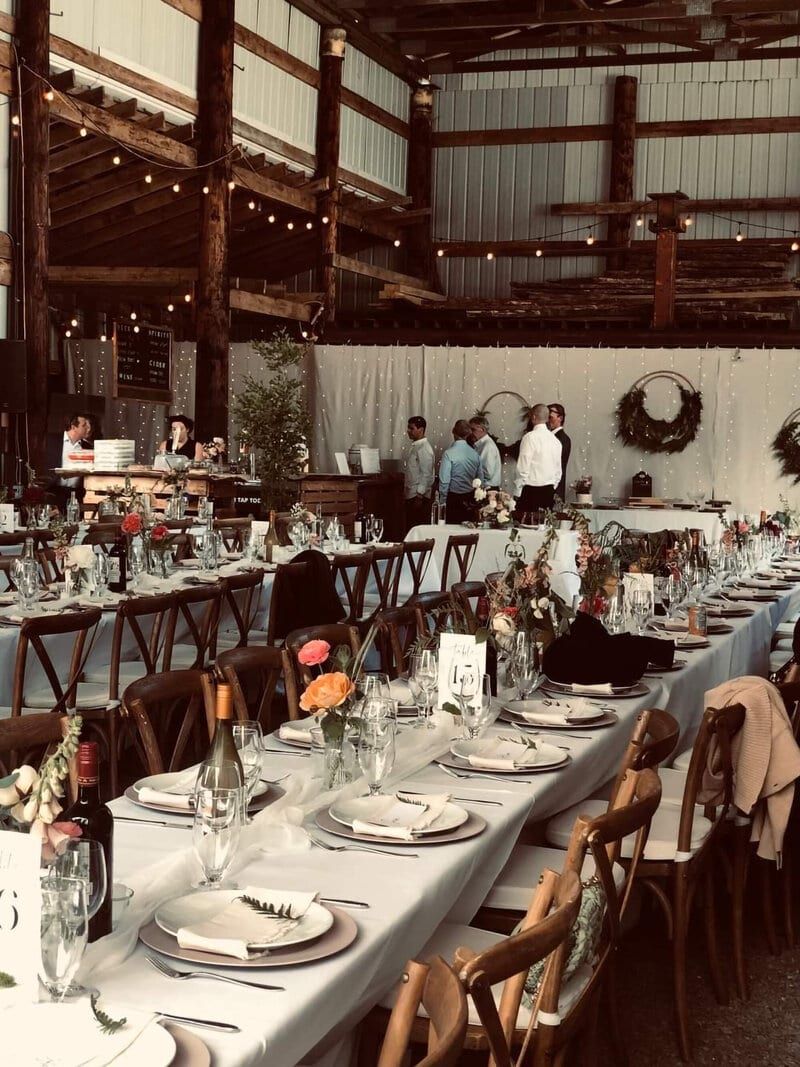 String-lit barn reception tables set by Triple T Party Rentals