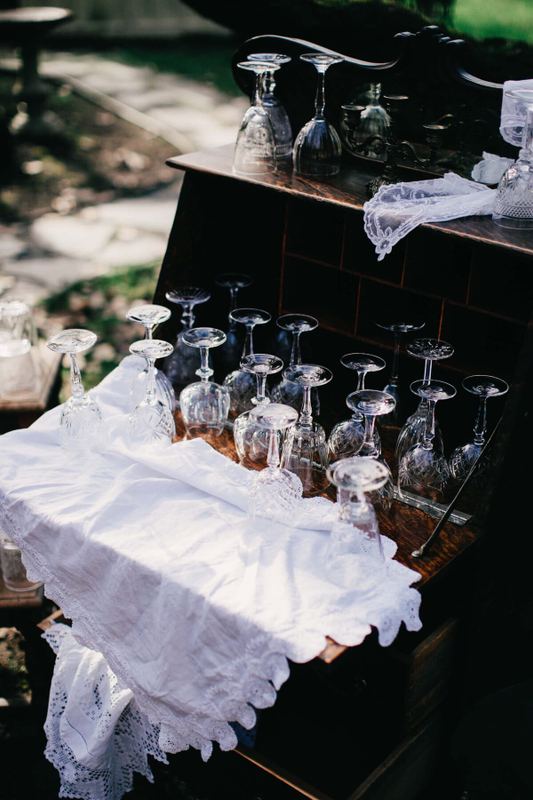 Upturned crystal stemware arranged on a lace-draped antique desk