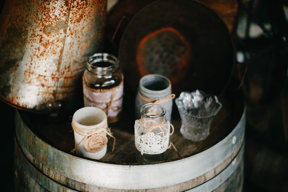 Twine-wrapped jars and lace votives styled on a barrel
