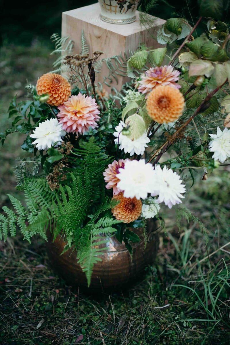 Copper urn of dahlias and ferns by Folklore Wedding Company