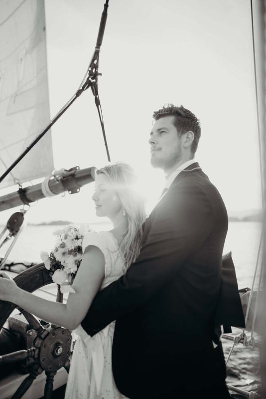 Sunlight flaring behind a couple steering the ship together