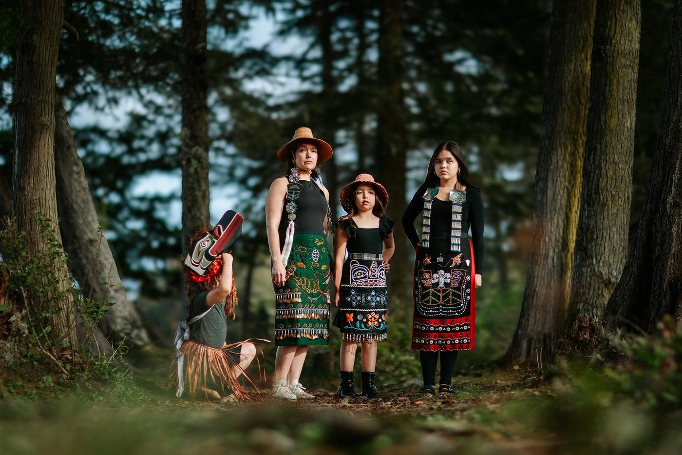 First nations family in regalia posing for photo by Kimberley Kufaas