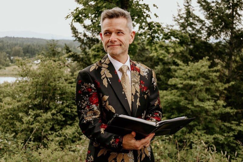 Celebrant James in a floral suit holding his ceremony book