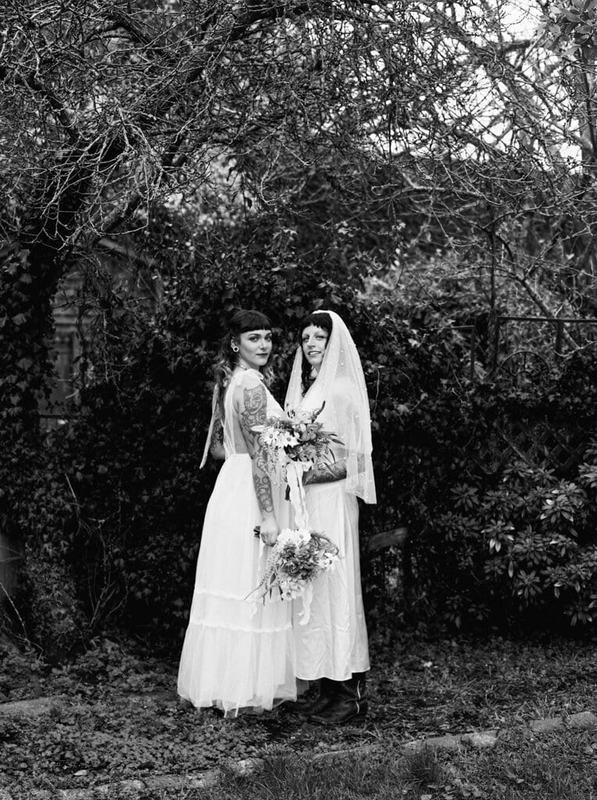 Black-and-white portrait of two brides in a wild winter garden