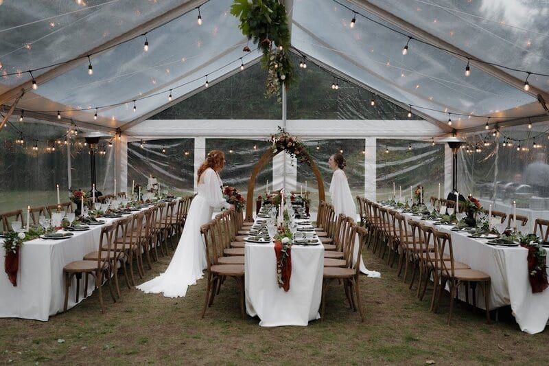 Long white tables under a clear-top tent from Black & White
