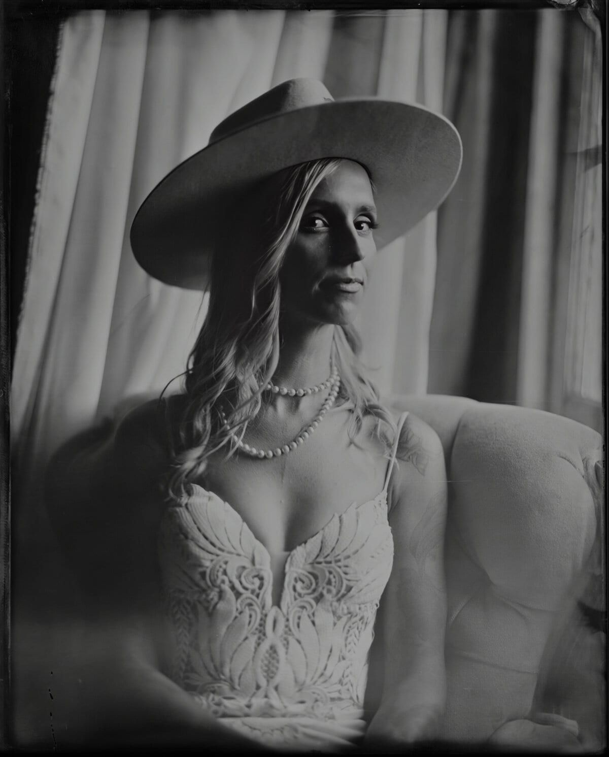 Bride in a wide-brimmed hat and pearls, tintype portrait