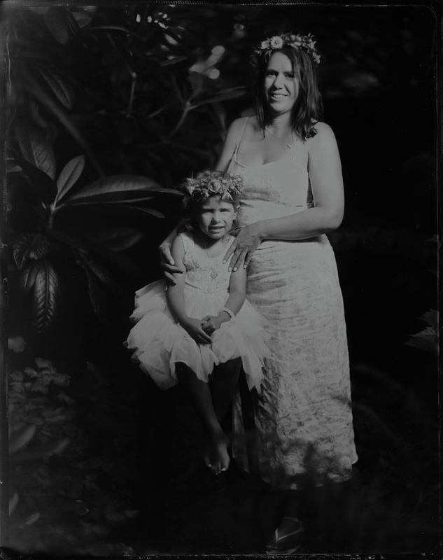 Flower-crowned mother with a little girl in a tulle dress