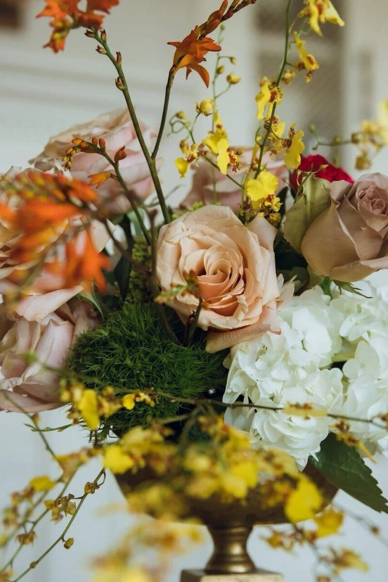 Blush roses and yellow orchids arranged by Three Chi's Acre