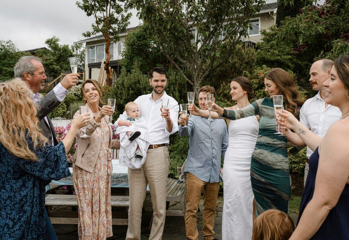 Wedding guests raising champagne flutes for a garden toast