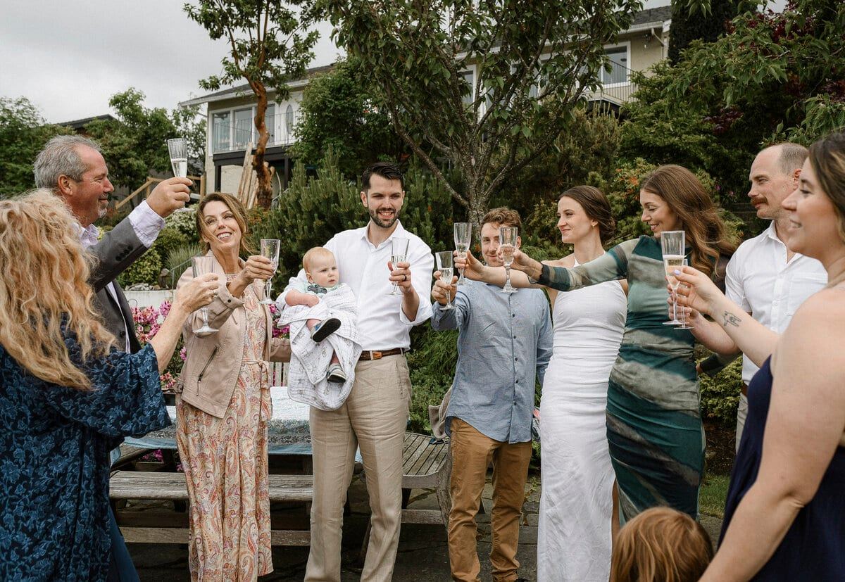 Wedding guests raising champagne flutes for a garden toast
