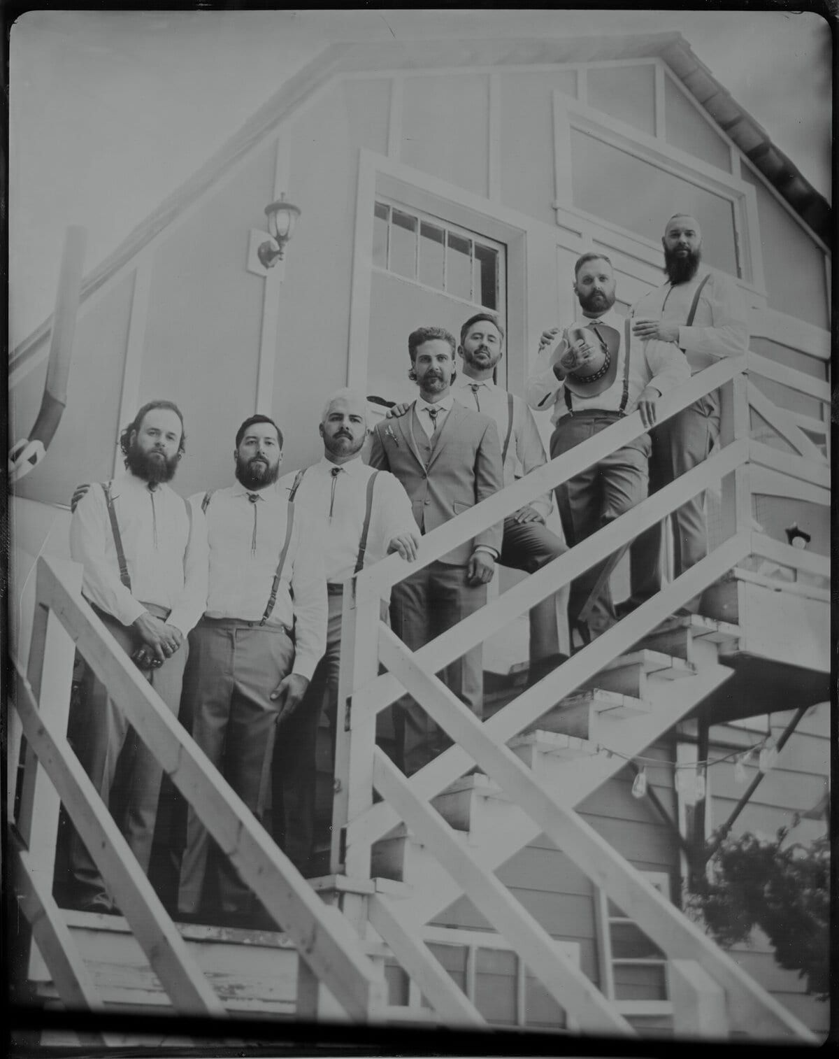 Groomsmen gathered on an outdoor staircase, wet-plate group shot