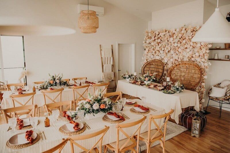 Boho reception with peacock chairs and flower wall by Timeless Party Rentals