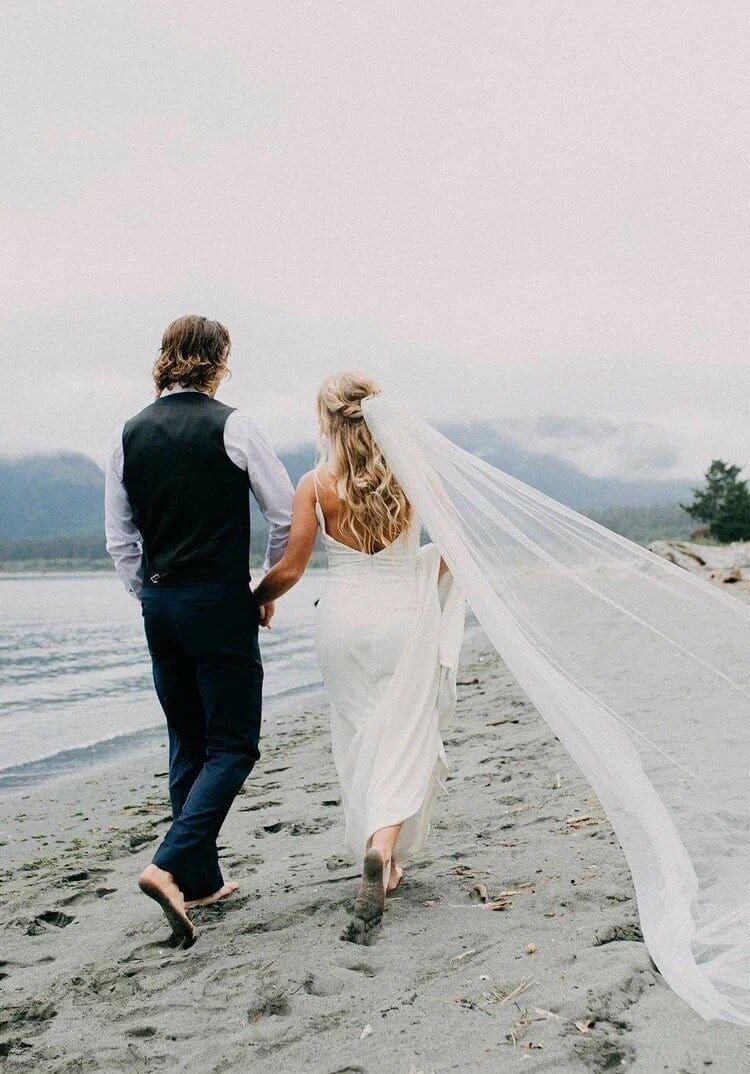 Newlyweds strolling the misty sand near Pacific Gateway Marina
