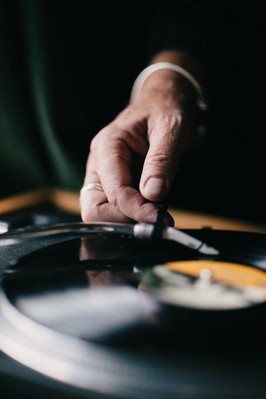 Hand lowering the needle onto a spinning record