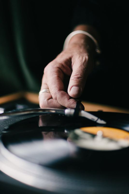 Hand lowering the needle onto a spinning record