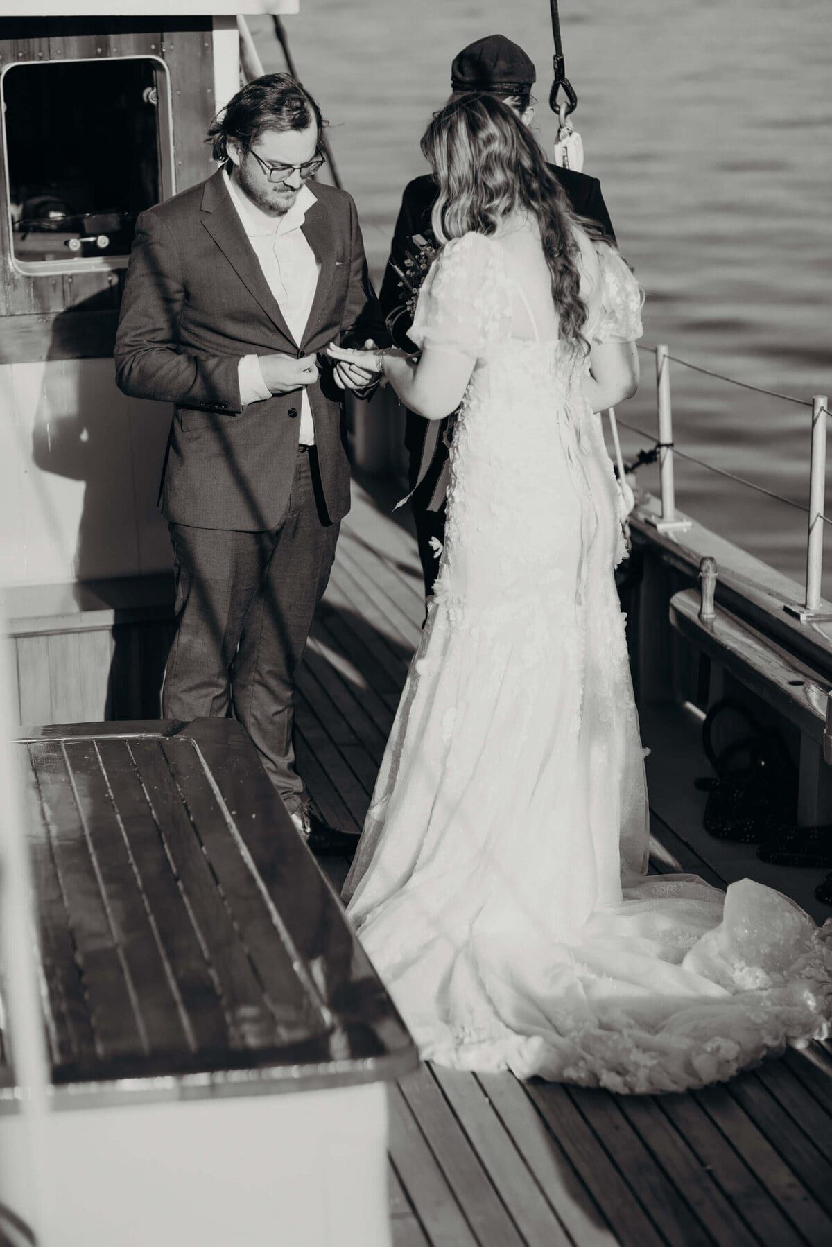 Man in a suit reading vows to the bride at the stern