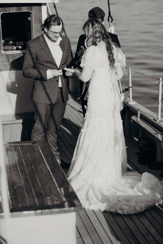 Man in a suit reading vows to the bride at the stern