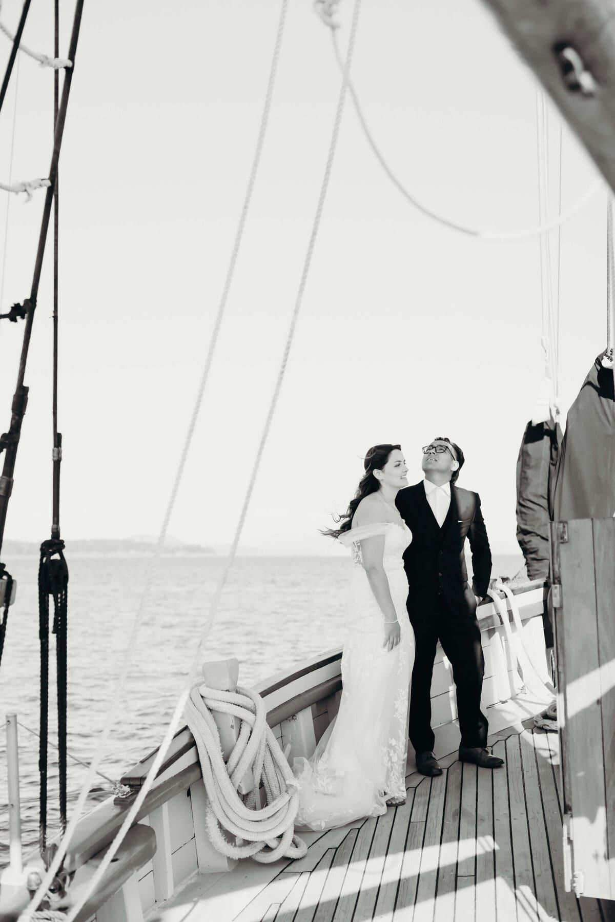 Newlyweds standing on the teak deck beside coiled lines