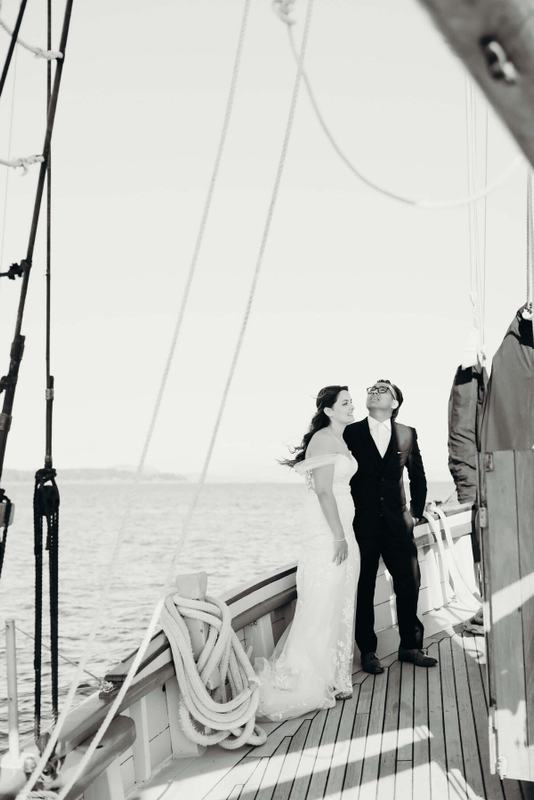 Newlyweds standing on the teak deck beside coiled lines