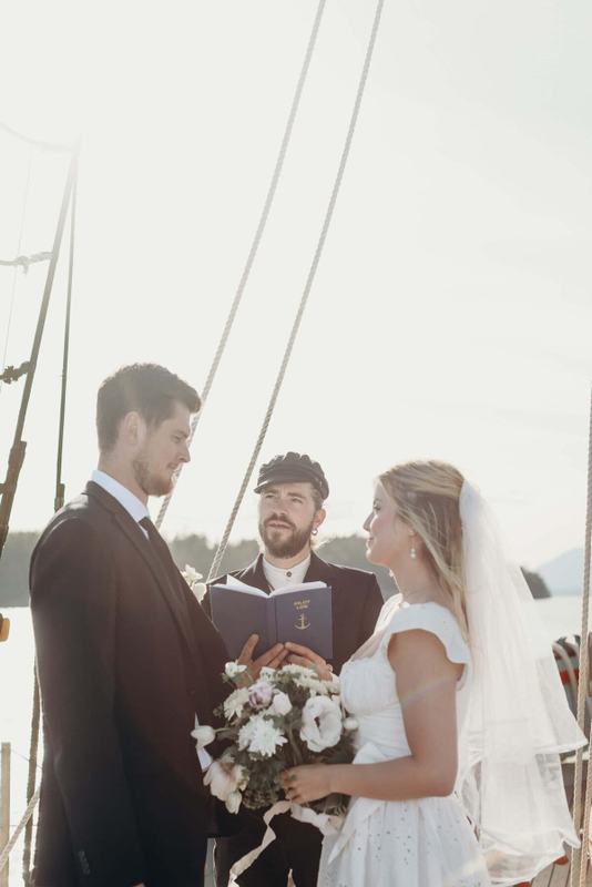 Captain in a fisherman's cap officiating a shipboard vow exchange