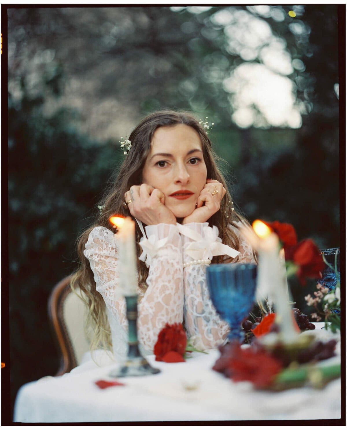 Bride in lace resting her chin in both hands