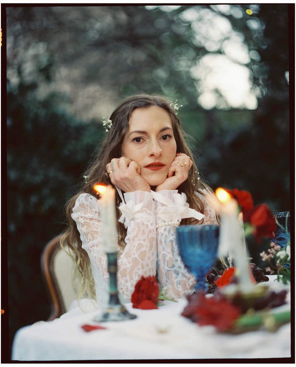 Bride in lace resting her chin in both hands
